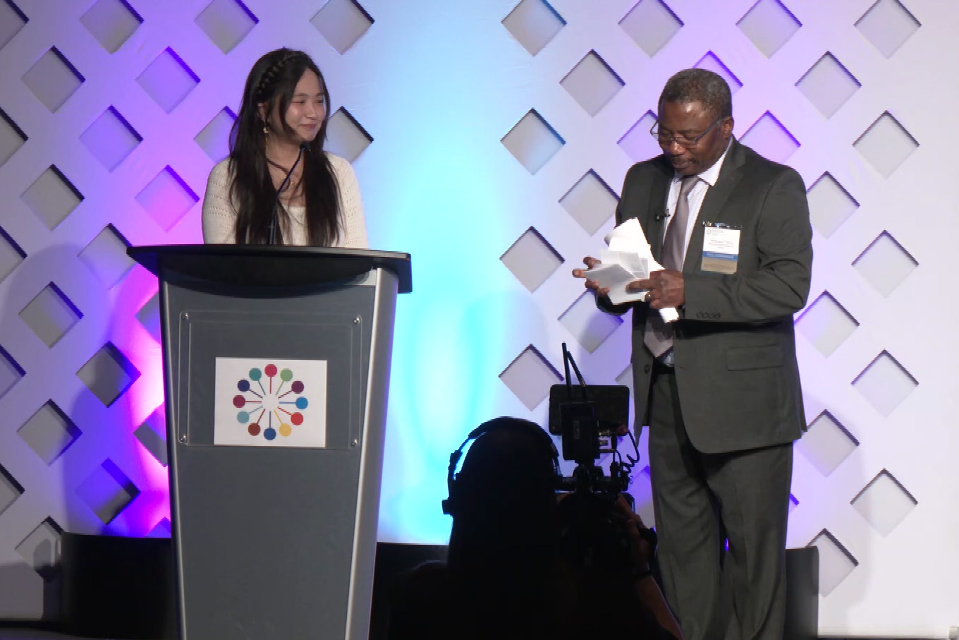 Speaker and moderator onstage at podium