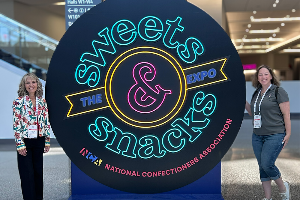 Yvette Thomas and Brandy Kresge with giant Sweets & Snacks sign